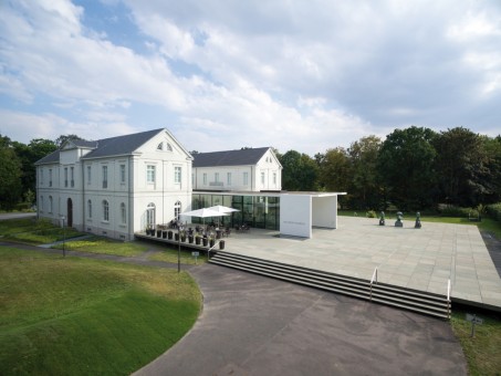 Foto: Museumsgebäude mit Skulpturen von Max Ernst im Vordergrund