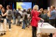 Blick in den Saal mit Informationsständen und Personen, die sich unterhalten.