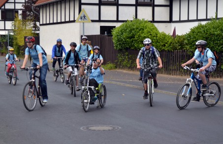 Gruppe von Kindern auf Fahrrädern und Handbikes.