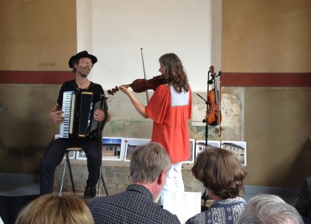 Eine Frau spielt Geige und ein Mann spielt Akkordeon.