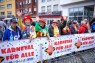 Man sieht eine Gruppe verkleideter Menschen vor mehreren Bannern der LVR-Initiative "Karneval für alle".