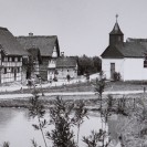 Historische Ansicht des Freilichtmuseums in Kommern, blick auf den See und die dahintergelegene Fachwerkhaussiedlung und Kirche.
