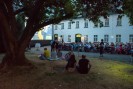 Foto: sitzende Menschen im Freien vor einer Leinwand