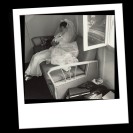 Foto: schwatz weisses Polaroid mit Frau im Brautkleid auf einemBett sitzend