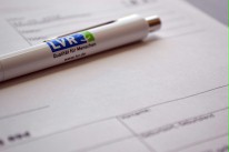 Ein Kugelschreiber mit LVR-Logo liegt auf einem Formular.