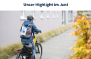 Man sieht eine Person von hinten, die auf einem Fahrrad fährt. Sie trägt eine blaue Regenjacke, einen Fahrradhelm und einen Rucksack mit LVR-Logo. Auf der rechte Bildseite steht ein Busch mit gelben Blättern.