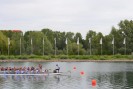 Zwei Drachenboote mit Menschen auf einem See.