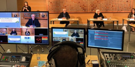 Eine Live-Pressekonferenz: im Vordergrund Monitore und Schnittpulte der Regie, im Hintergrund die Teilnehmer*innen der Pressekonferenz. Foto: Sophia-Ly Weidner / LVR
