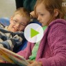 Standbild eines Videos: Ein Mädchen und ein Junge schauen sich ein Buch an