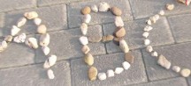 Mit Steinchen gelegtes "ABC" auf dem gepflasterten Boden