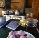 Einblick in eine alte Küche in einem Lehmhaus mit bunten Eiern und Töpfen