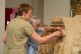 Das Foto zeigt einen blinden Mann, der mit Hilfe einer Museumspädagogin einen römischen Matronen-Stein erstastet.