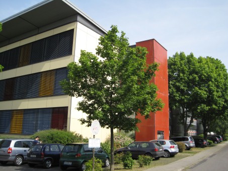 Hell gestrichenes Schulgebäude mit 3 Stockwerken an einer Strasse