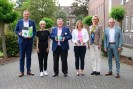 Die Personen schauen freundlich in die Kamera und halten eine Urkunde sowie einen Award mit der Aufschrift BEM.